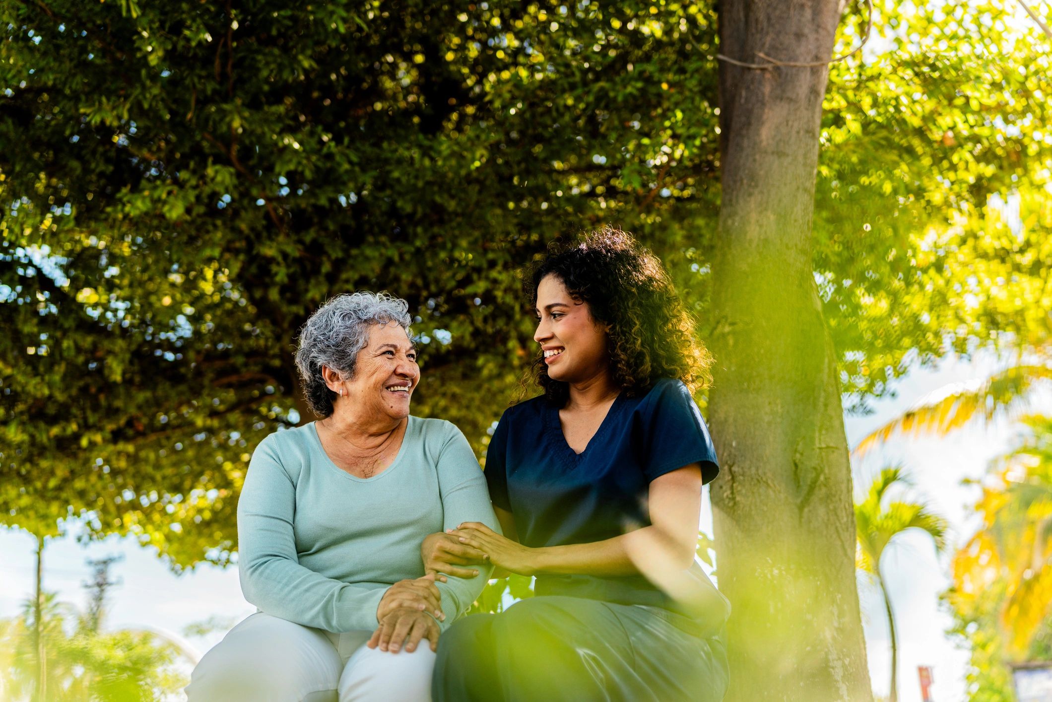 Caregiver speaking with a senior woman outdoors